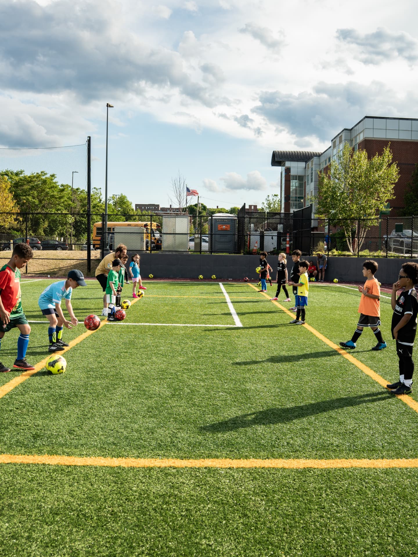 Coach leading a dribbling drill line with young players